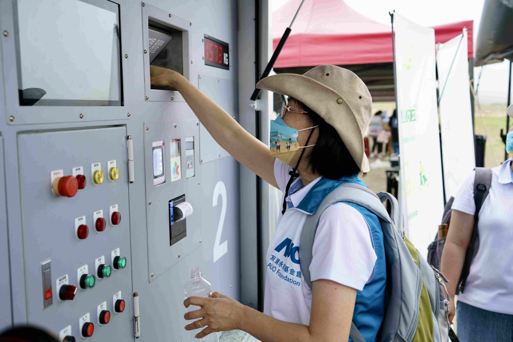 志工們將拾起的寶特瓶投入「好歸塑專車」，讓廢棄塑料空瓶可以直接粉碎、縮小體積，未來將可再製成購物袋、寶特衣、悠遊卡等生活用品